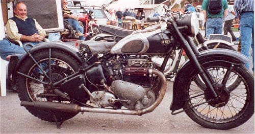 Telescopic forks, smiling gnome behind rear wheel.